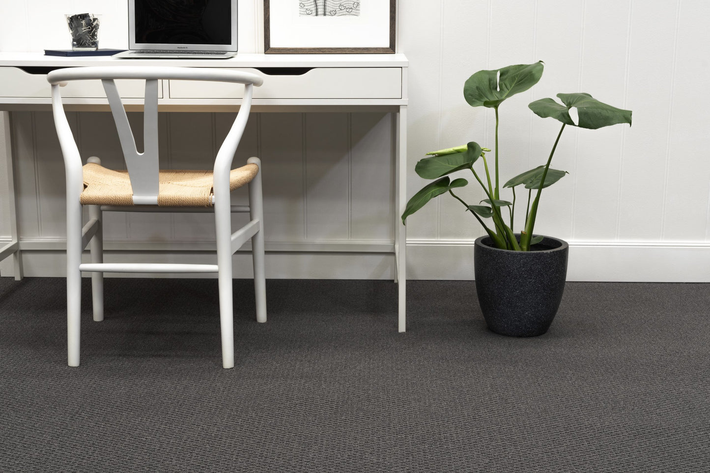Modern office setup with a desk, chair, and potted plant.