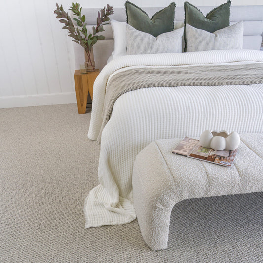 Bedroom with a bed on a textured gray carpet