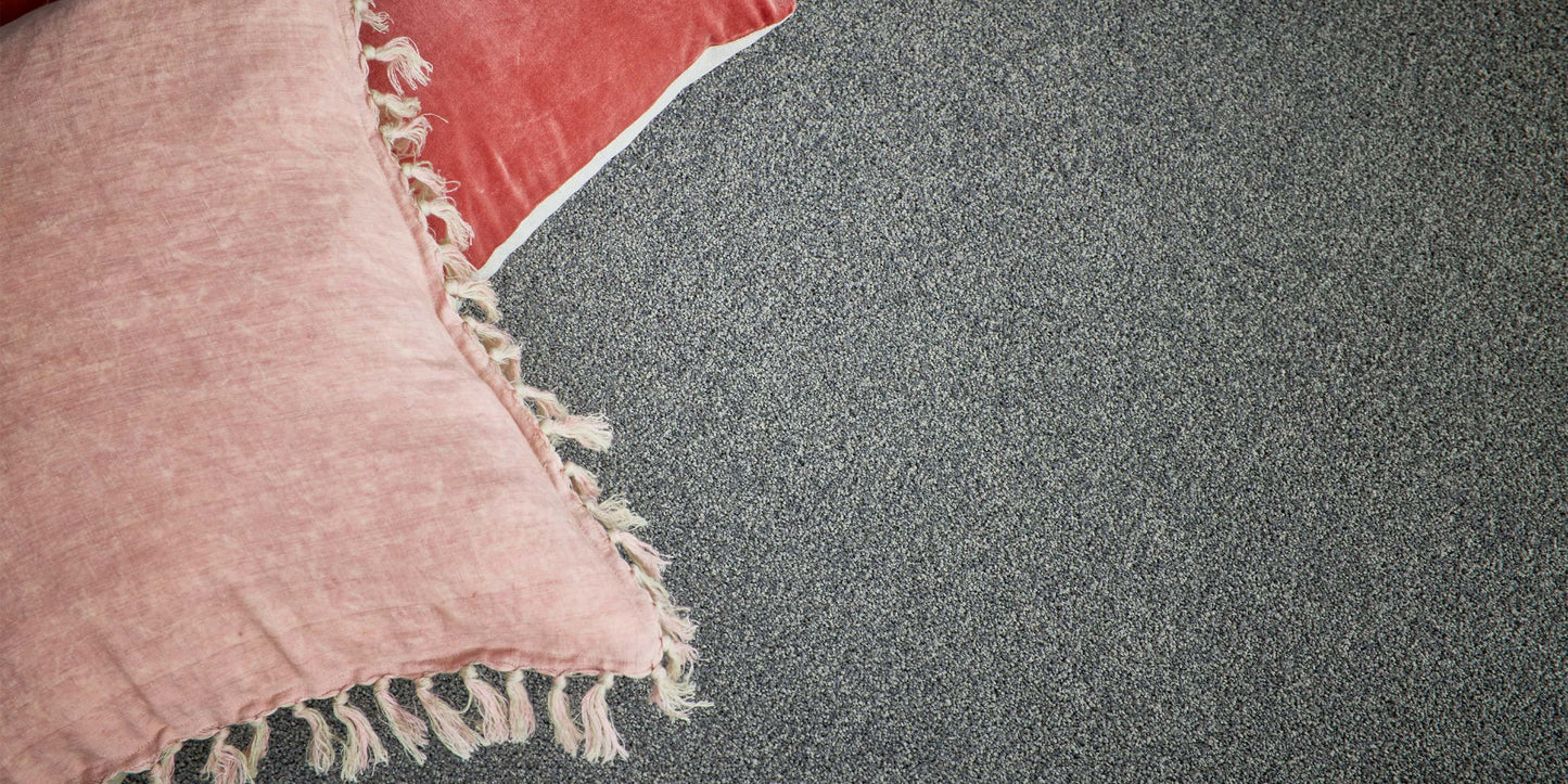 Textured pink and red pillows on Beacon carpet from Supreme Touch.