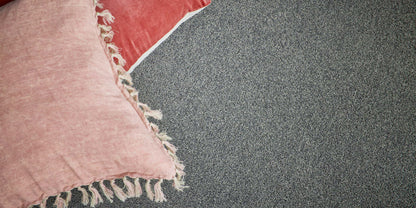 Textured pink and red pillows on Beacon carpet from Supreme Touch.